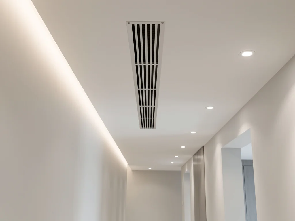 Grille de diffusion d'une climatisation gainable encastrée dans le plafond d'un couloir